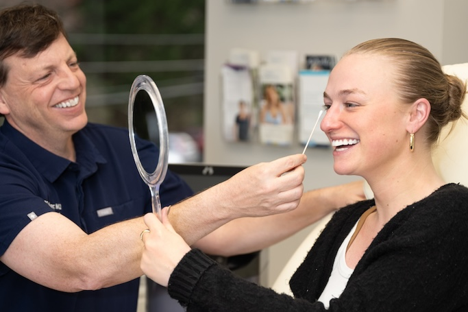 Dr. Faulkner indicates to a patient where he could place dermal fillers under eyes in Bethesda, MD.