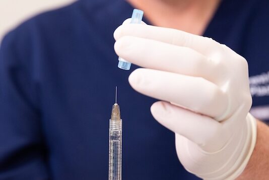 Dr. Faulkner prepares a syringe for injecting dermal fillers under eyes in Bethesda.