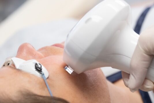 A provider applies the Lumecca IPL device to a patient's midface during her facial rejuvenation in Bethesda.